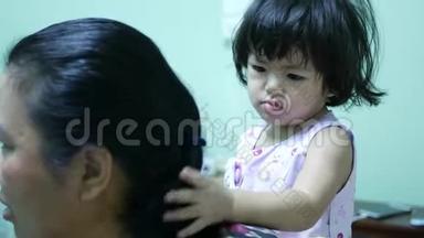 小亚洲女孩给她阿姨做`头发-通过学习为别人做事情来发展孩子